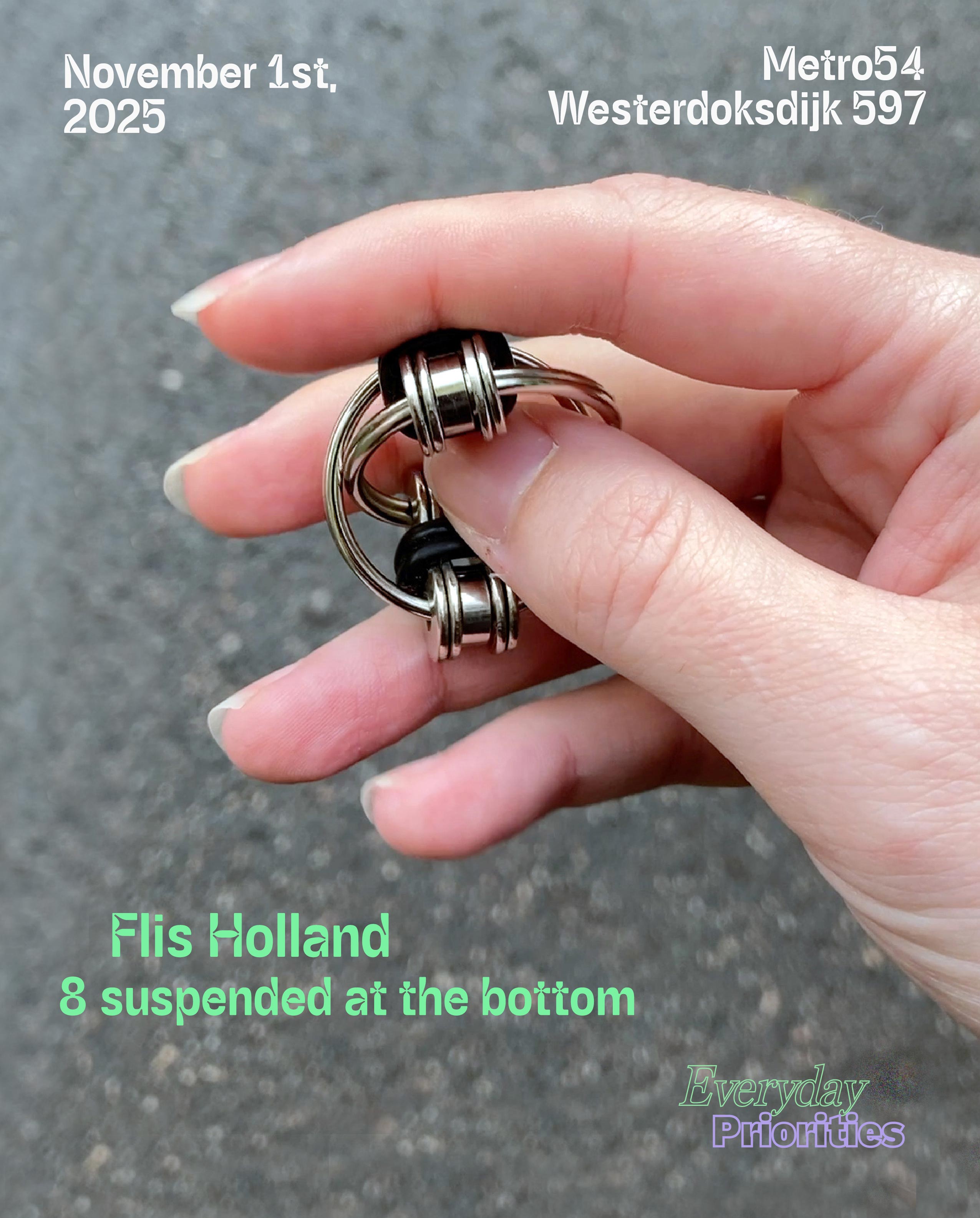 Close-up of a hand playing with a stim toy, interlocking metal rings that flip in and out of each other.