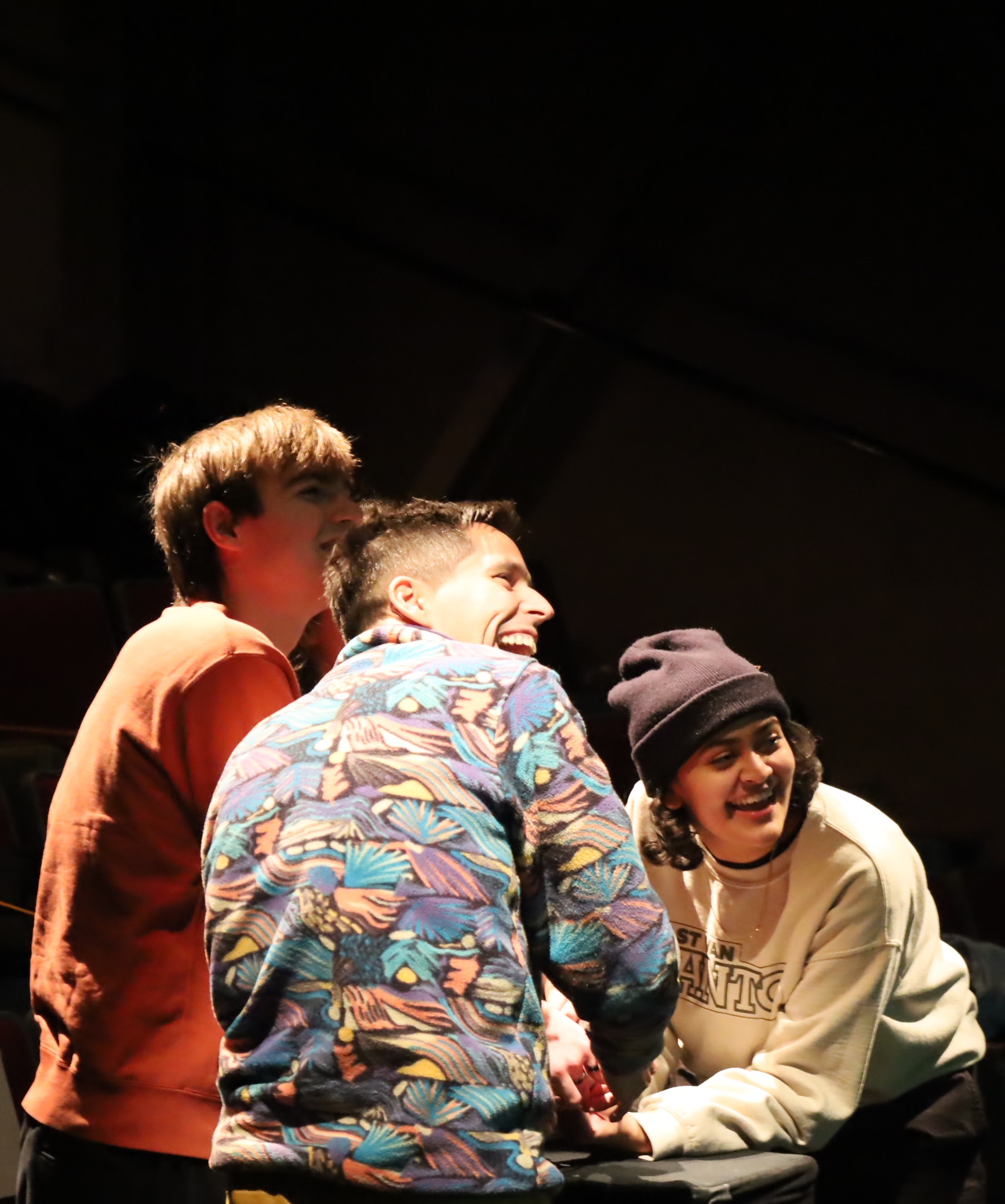 Three people laughing together while playing a game.