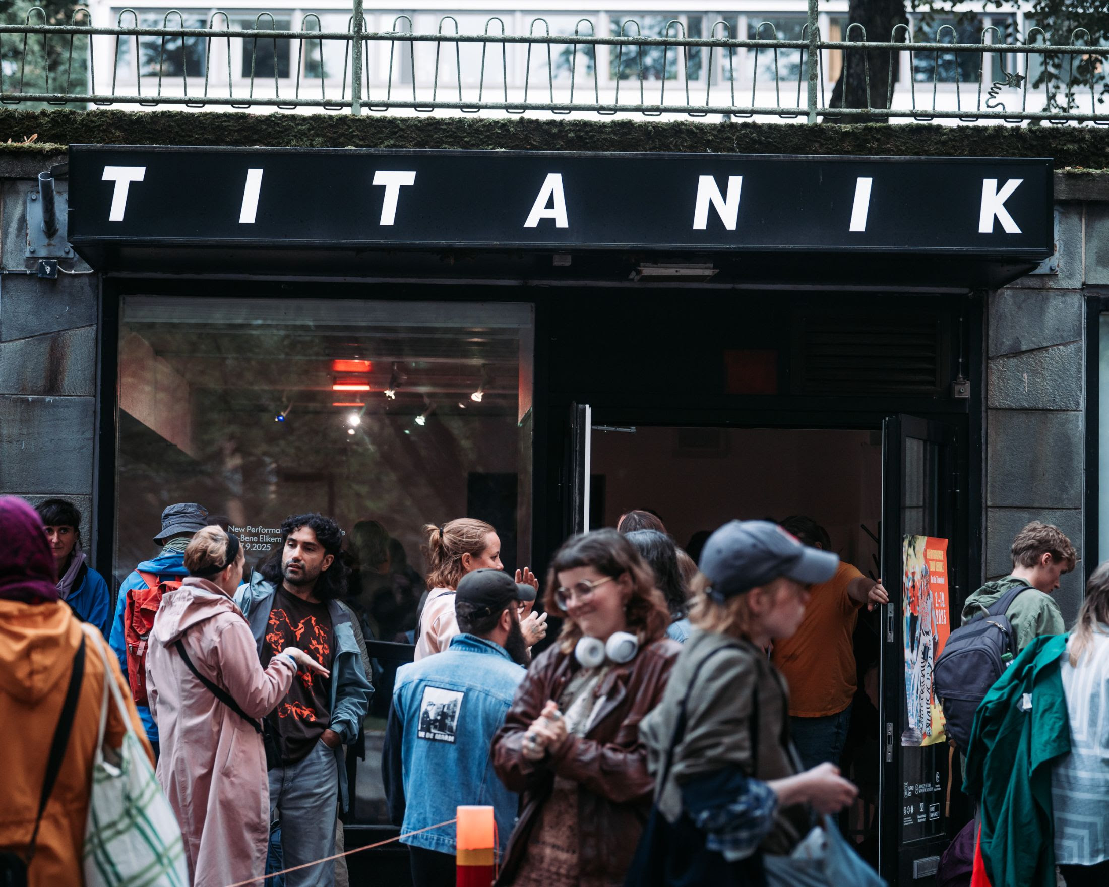 People are chatting in front of a gallery entrance