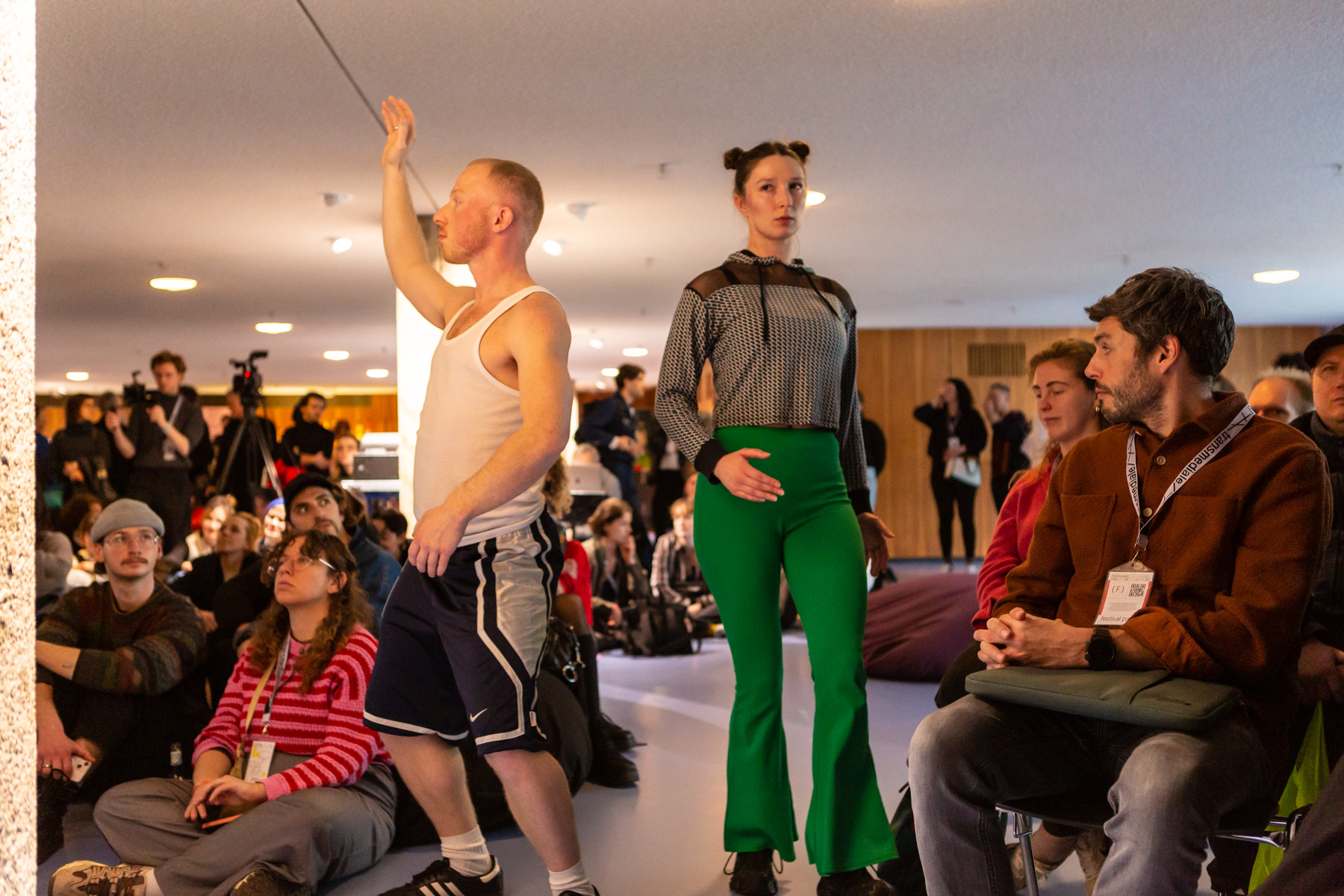Two people in the middle of an audience taking poses to imitate game characters.