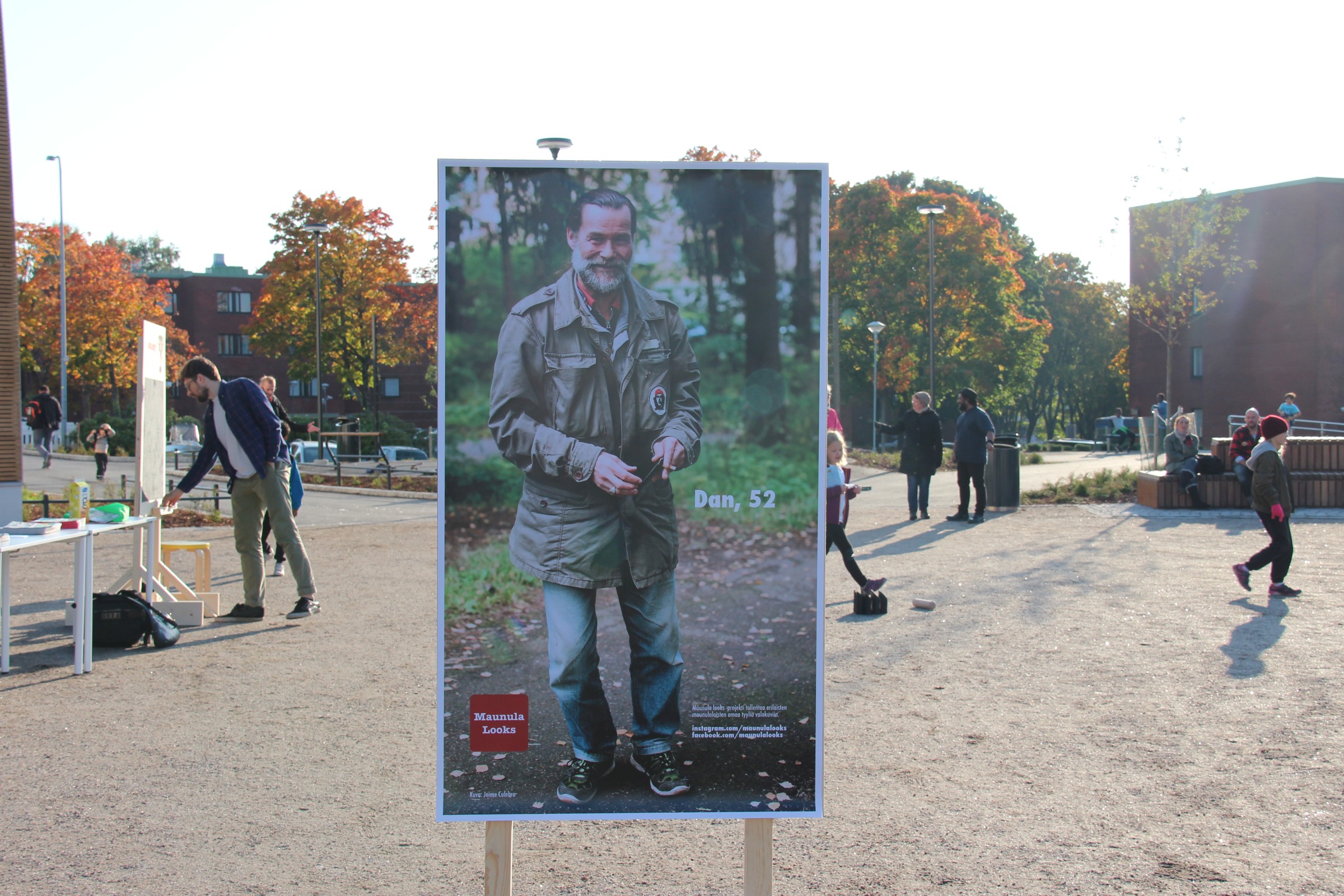 Printed picture of Dan, people playing Mölkky in the background