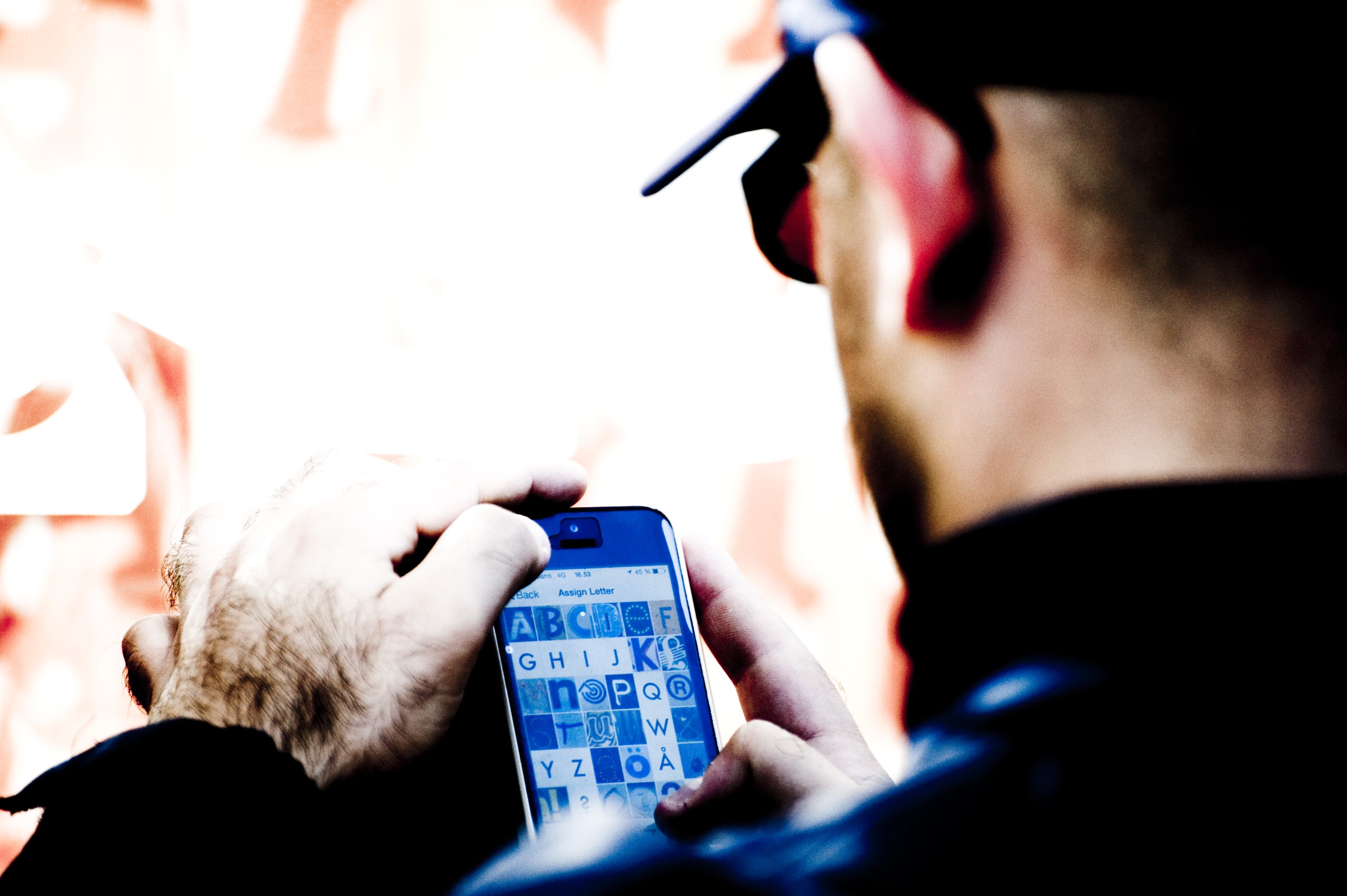 Urban Alphabets workshop, participant looking at the letters on their phone